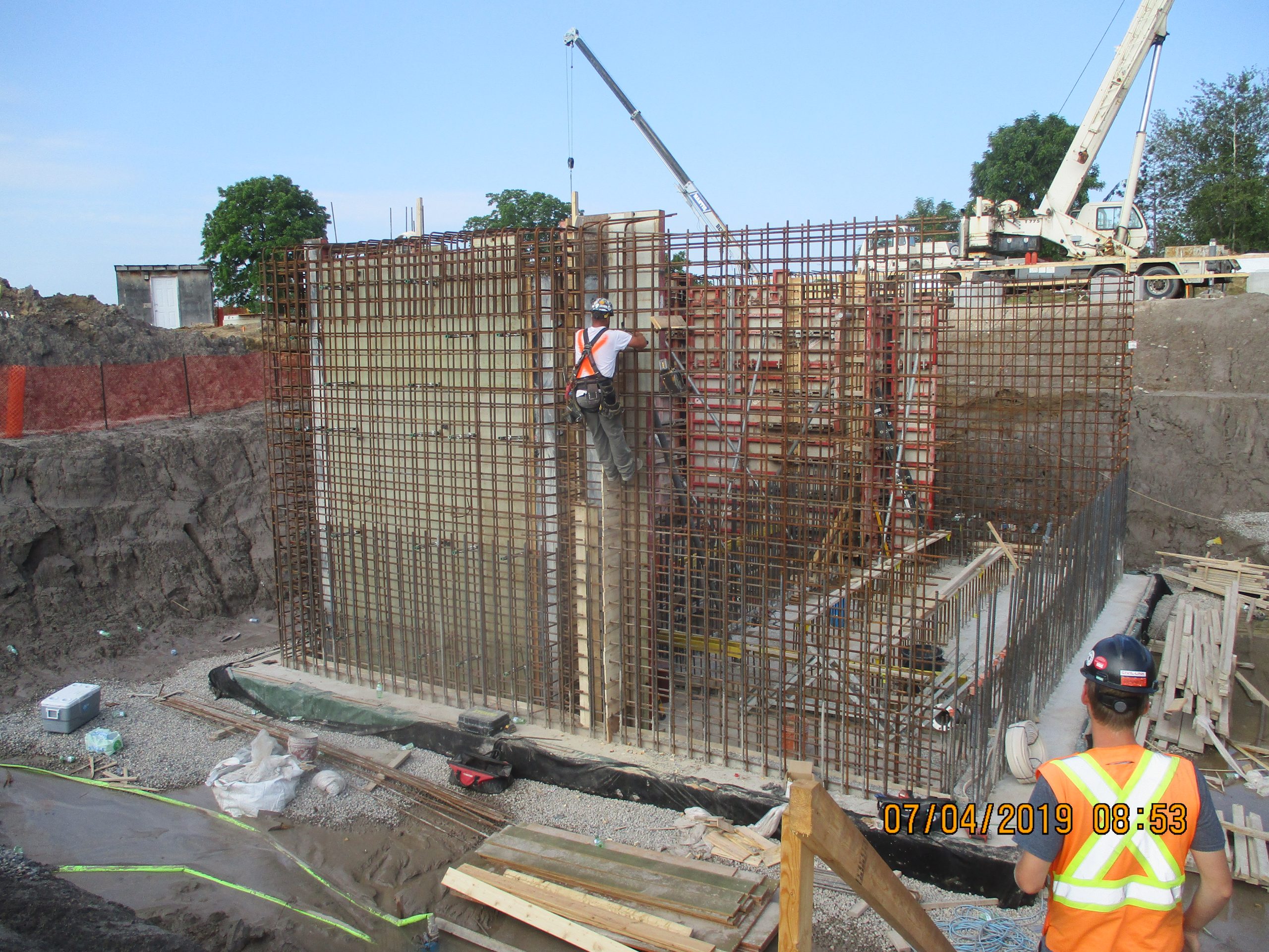 A construction worker wearing a hard hat is focused on their task at a construction site.