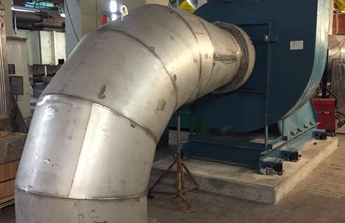 A steel pipe is shown in an industrial environment, highlighting the machinery and engineering involved in construction.