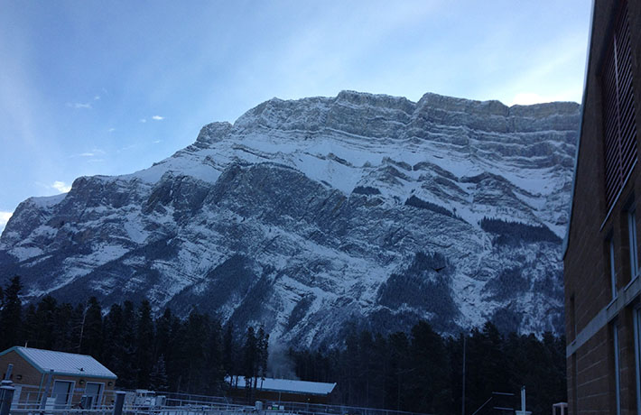 Snowy mountain landscape with a house in the foreground, showcasing the beauty of winter.